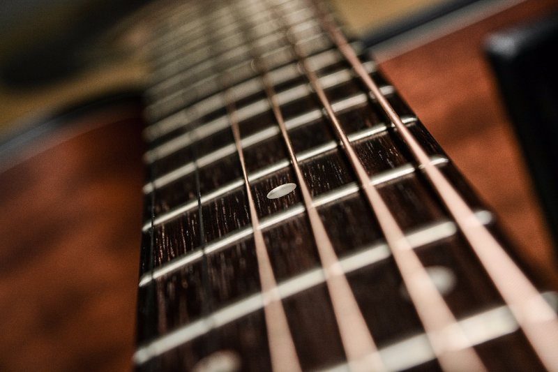 [url=https://remote.rsccd.edu/en/musical-instrument-string-instrument-1283362/,DanaInfo=pixabay.com,SSL+]"Guitar Fretboard"[/url] by Pexels is in the [url=https://remote.rsccd.edu/publicdomain/zero/1.0/,DanaInfo=creativecommons.org+]Public Domain, CC0[/url]
Guitar strings that were carefully excited to contain only even harmonics.  Notice the node of the vibration in the picture.  You will witness such vibrations in lab today.