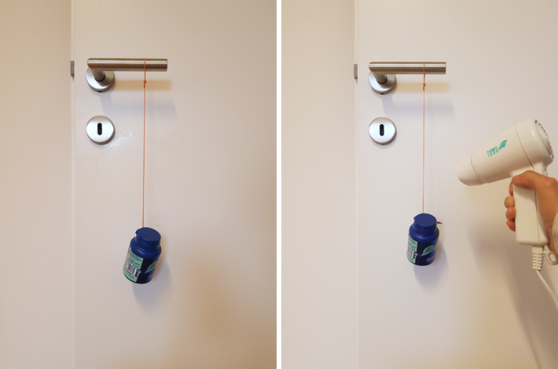 Experimental setup with rubber band and weight mounted on a door handle and heating of rubber band with a hair dryer.